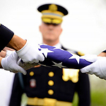Hands holding a folded American flag