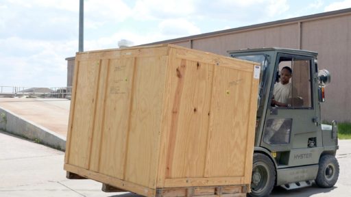 Fork lift carries wooden moving box