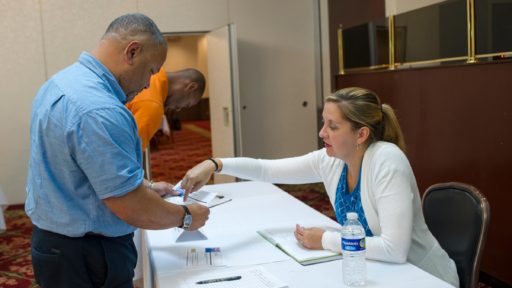 Two people discuss handout during a job fair