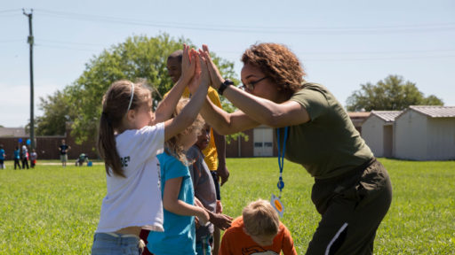 Child high fiving adult at community event