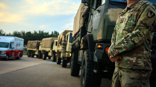 soldier stands next to truck