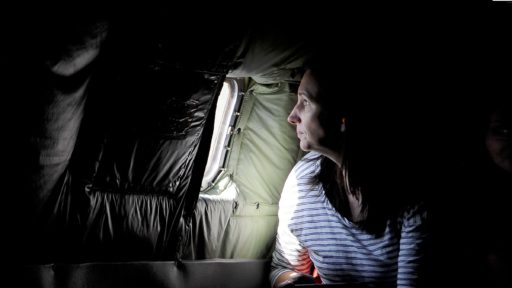 A military spouse looks out a KC-135 Stratotanker window during takeoff as part of a spouse familiarization flight