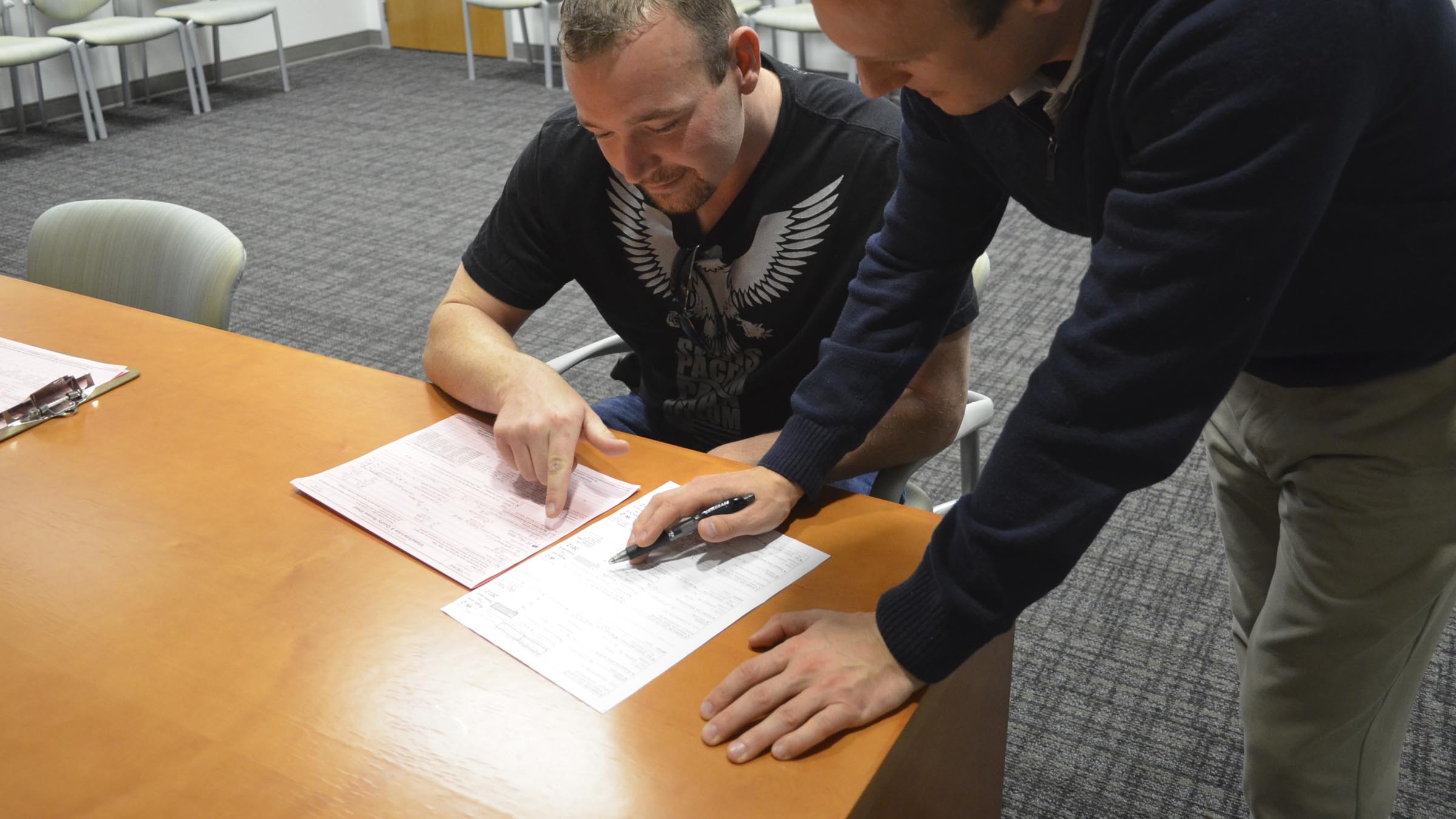 Man helping another man with filing paperwork