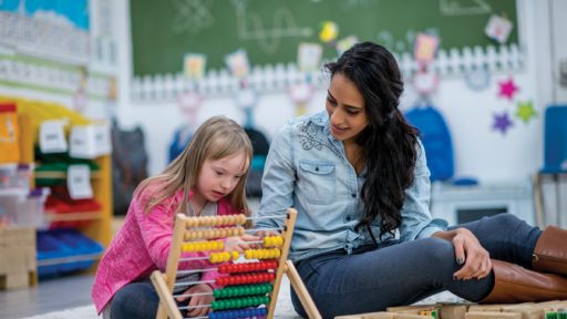Teacher working with special needs child in classroom