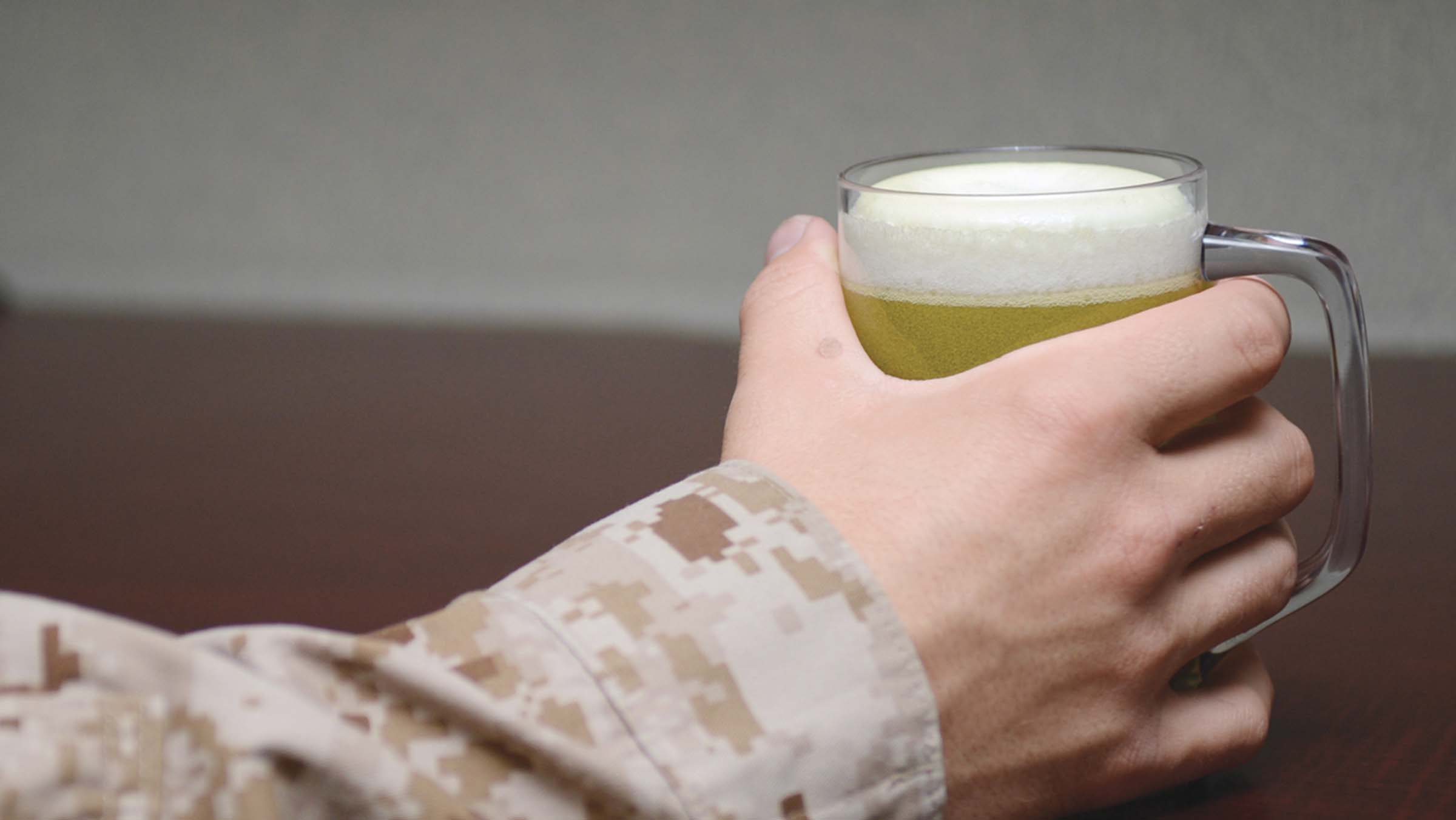 Service member’s hand holding a beer.