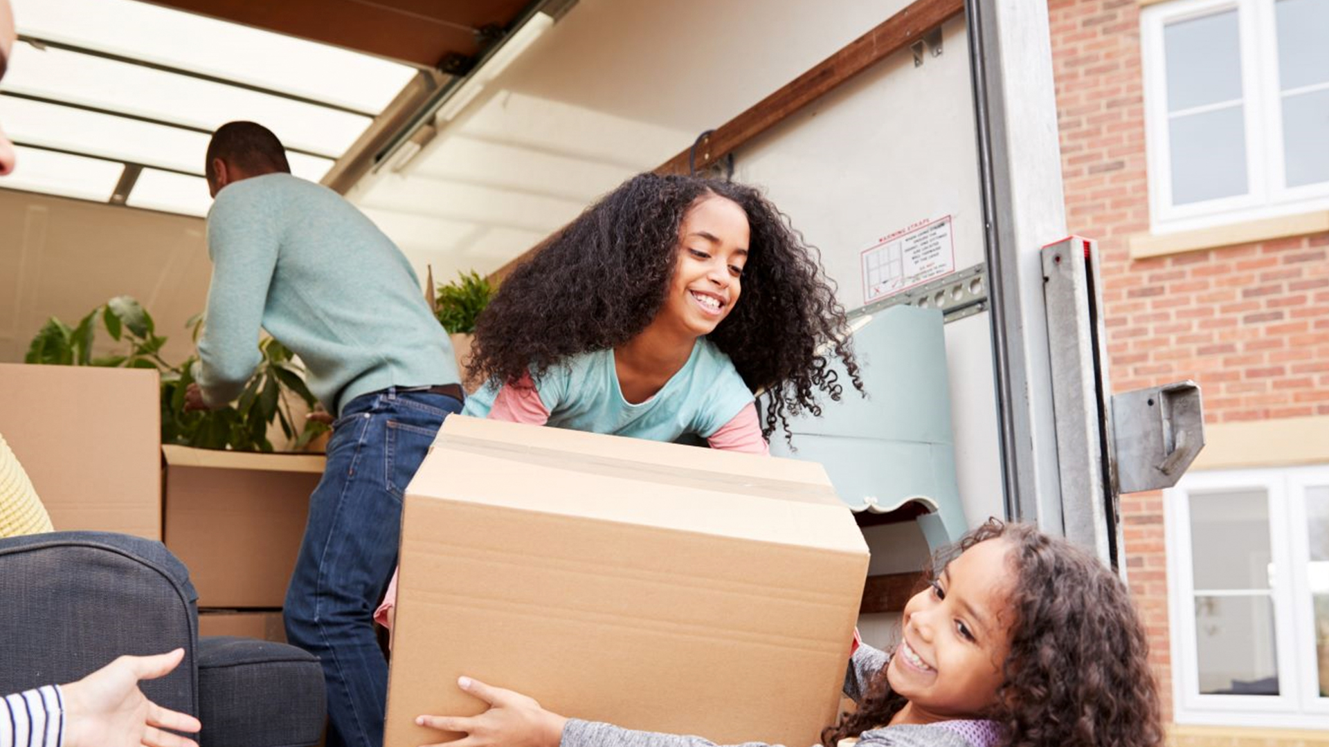 Family unloading moving truck together