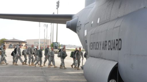 A group of National Guard soldiers board a military cargo plan after an exercise.