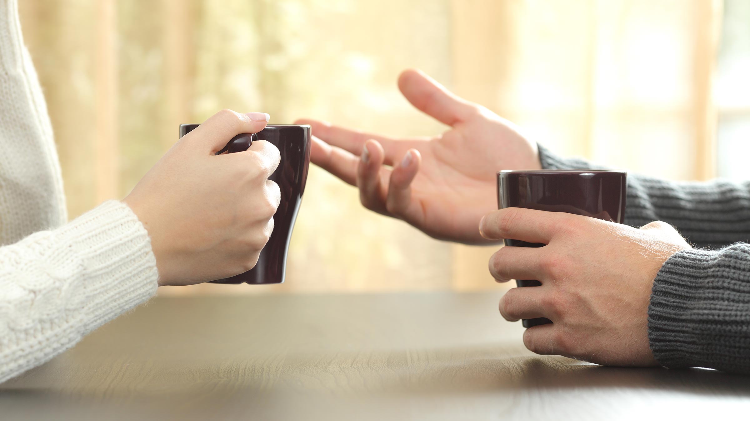 Hands of friends with coffee cups.