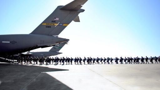 Service members departing from an airplane