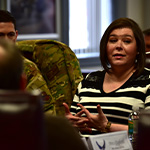 a woman talks with service members