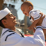 navy father lifts baby