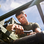 service member working on a water pump