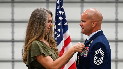 service member receives retirement pin from wife