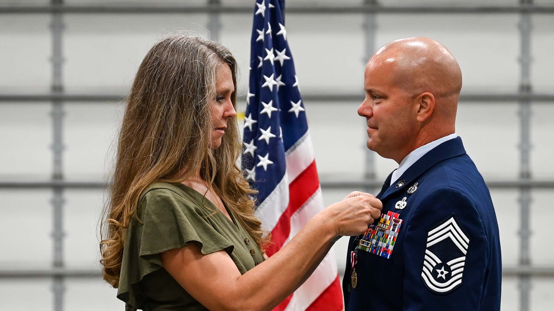 service member receives retirement pin from wife