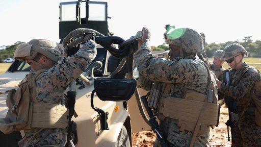 service members prepare vehicle for transport