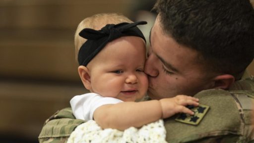 Military dad kisses baby girl