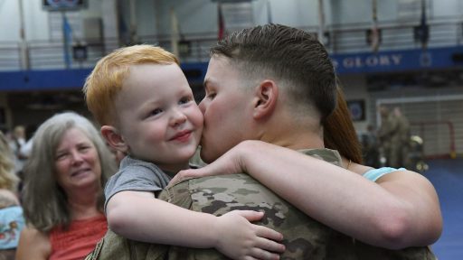 Service member embraces son.