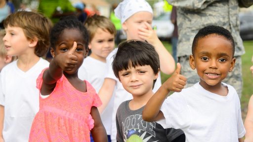 Young children give a thumbs up
