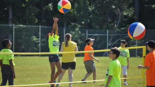Youth playing volleyball outside