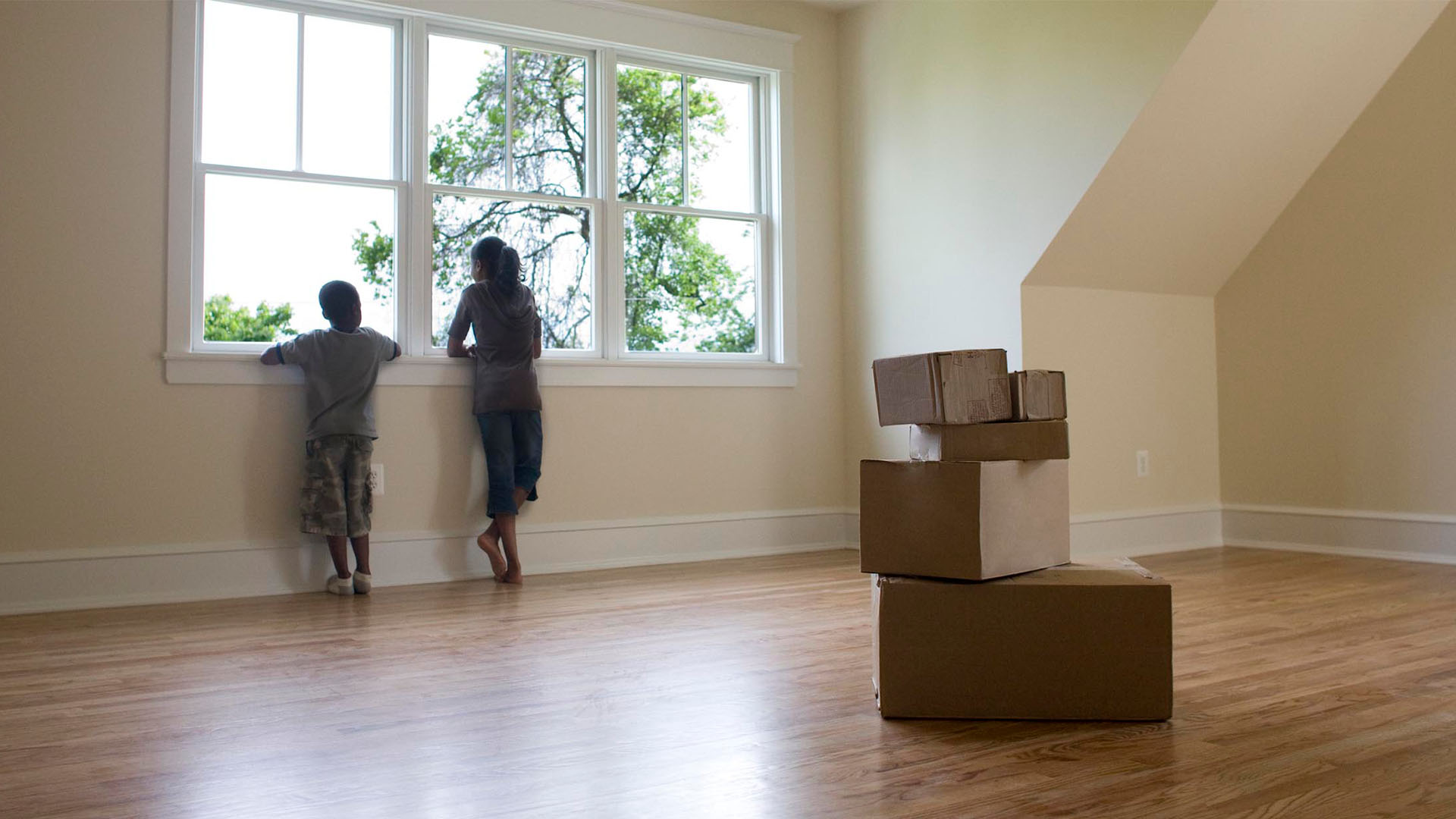 Children in new home with moving boxes