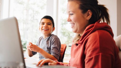 Mom on computer beside special needs child