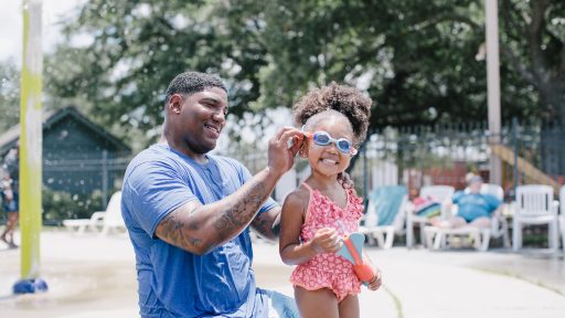 Father helping daughter with goggles
