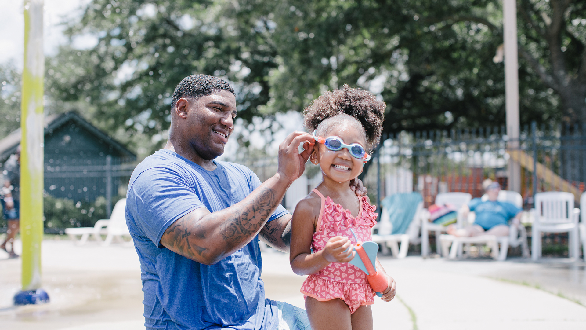 Father helping daughter with goggles