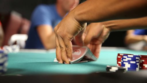 hands shuffling cards on table with poker chips