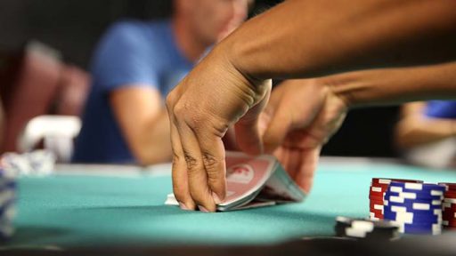 hands shuffling cards on table with poker chips