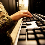 Hands typing on paperwork