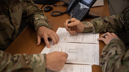 airmen briefing at desk with paperwork