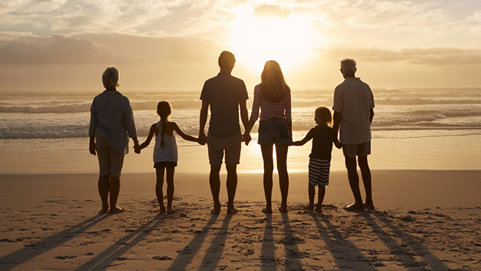 family holding hands at beach