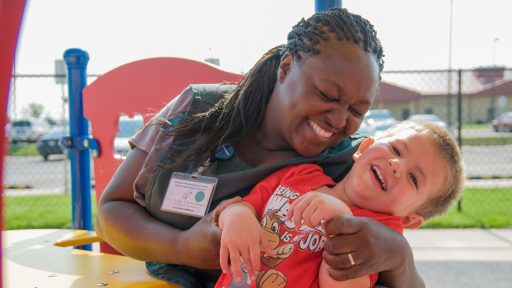 Child care provider laughs with little boy