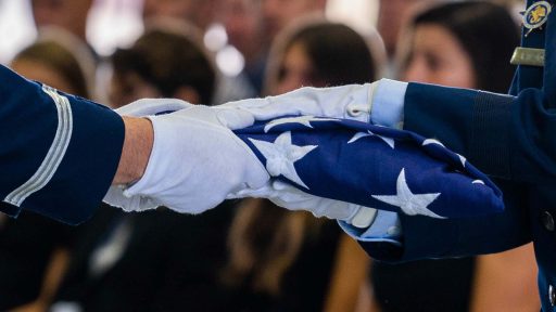 gloved hands holding flag