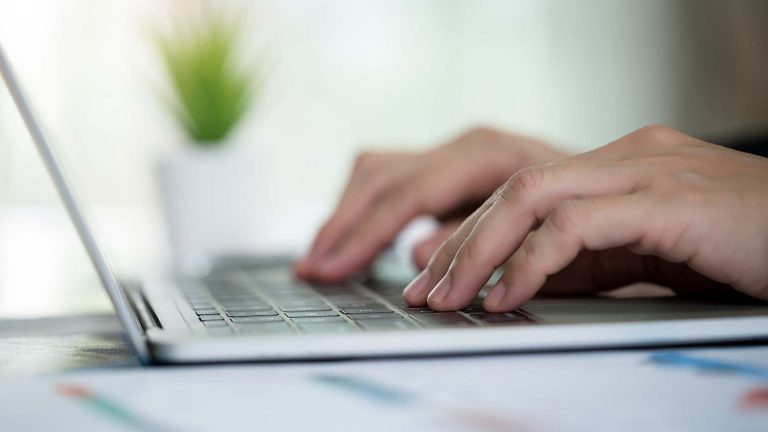 hands typing on laptop