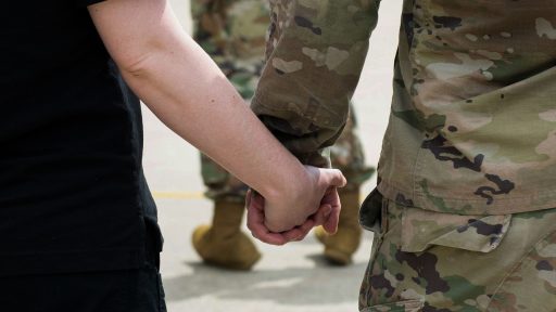 Soldier holds hands with partner
