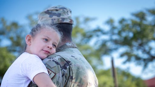 Child hugging service member parent