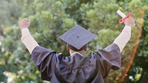graduate in cap and gown celebrating