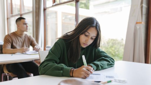 high school student writing in class