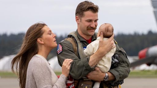 service member holding baby with spouse
