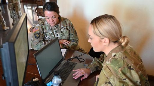 two service members on computer