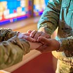 Soldiers hold hands in support
