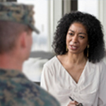 Woman speaking to service member