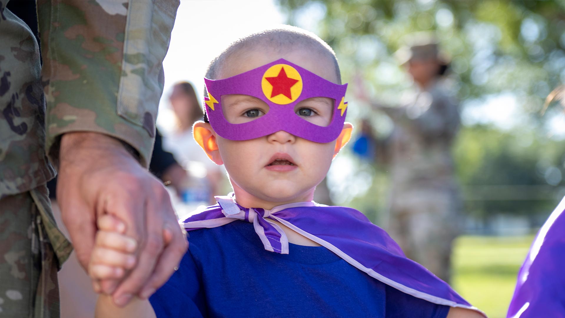 Military child wearing mask and cape