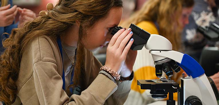 student using microscope