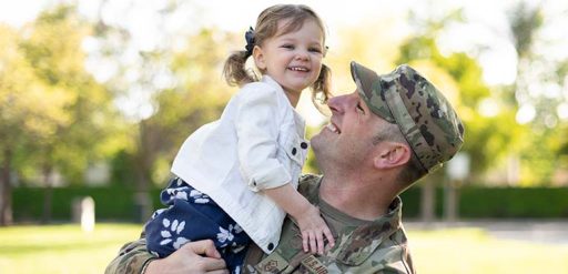 service member holding child