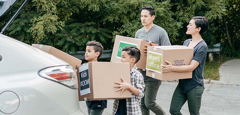 Family carrying moving boxes