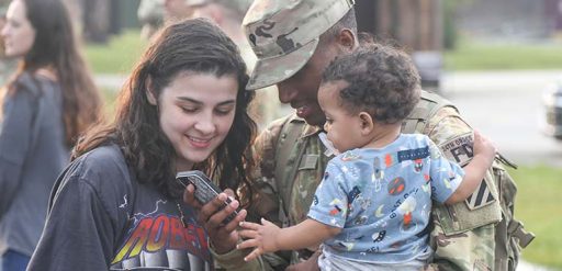 Service member and family looking at phone