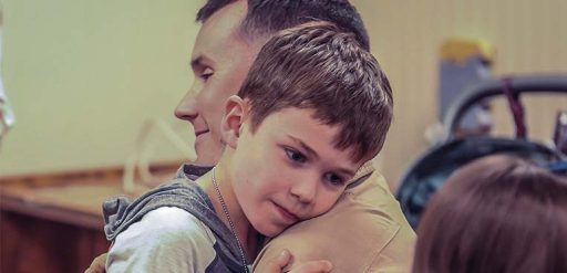 Service member hugging child