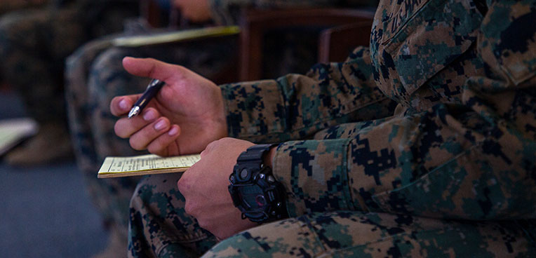 service member writing on notepad